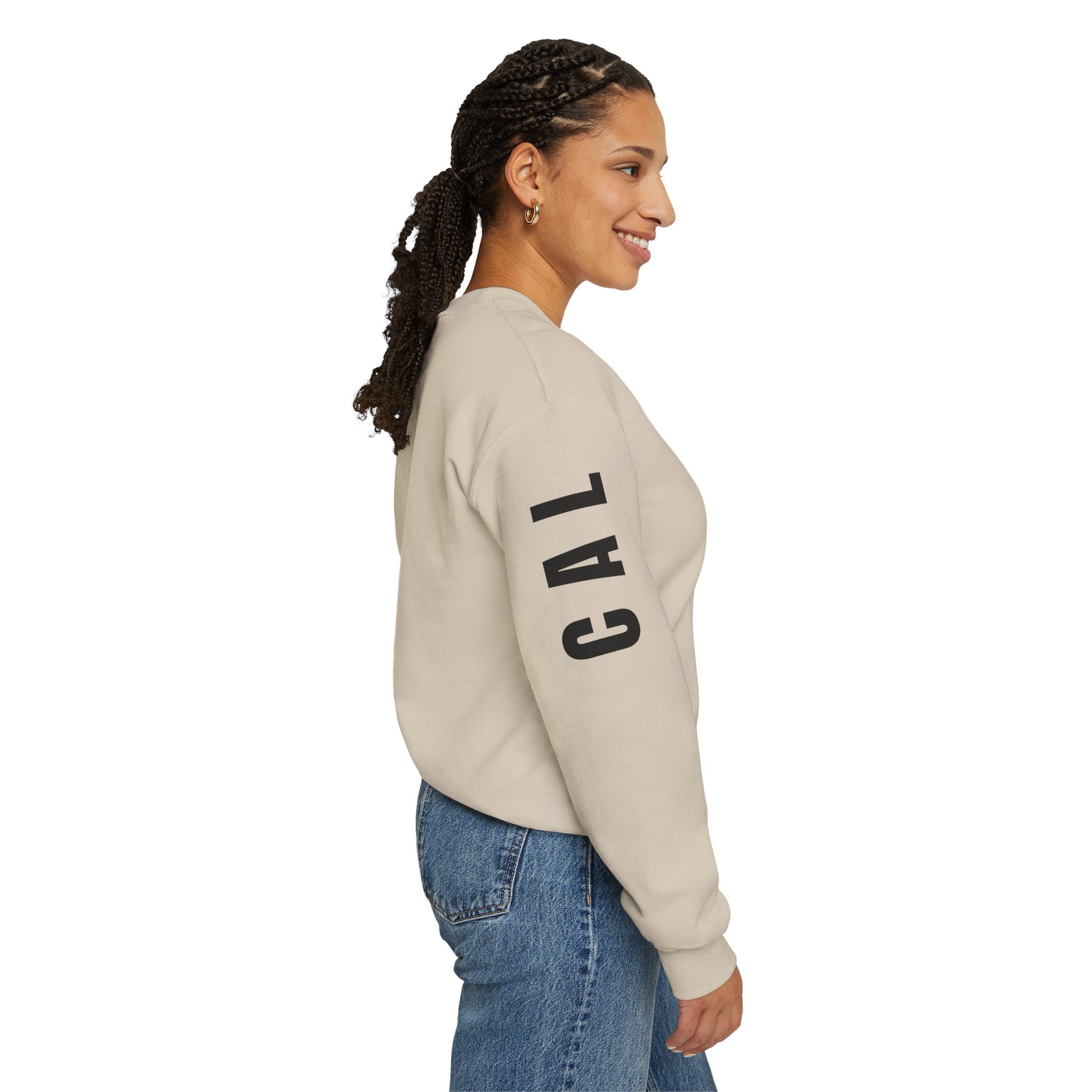 Woman wearing a beige sweatshirt with 'CAL' printed on the sleeve against a white background