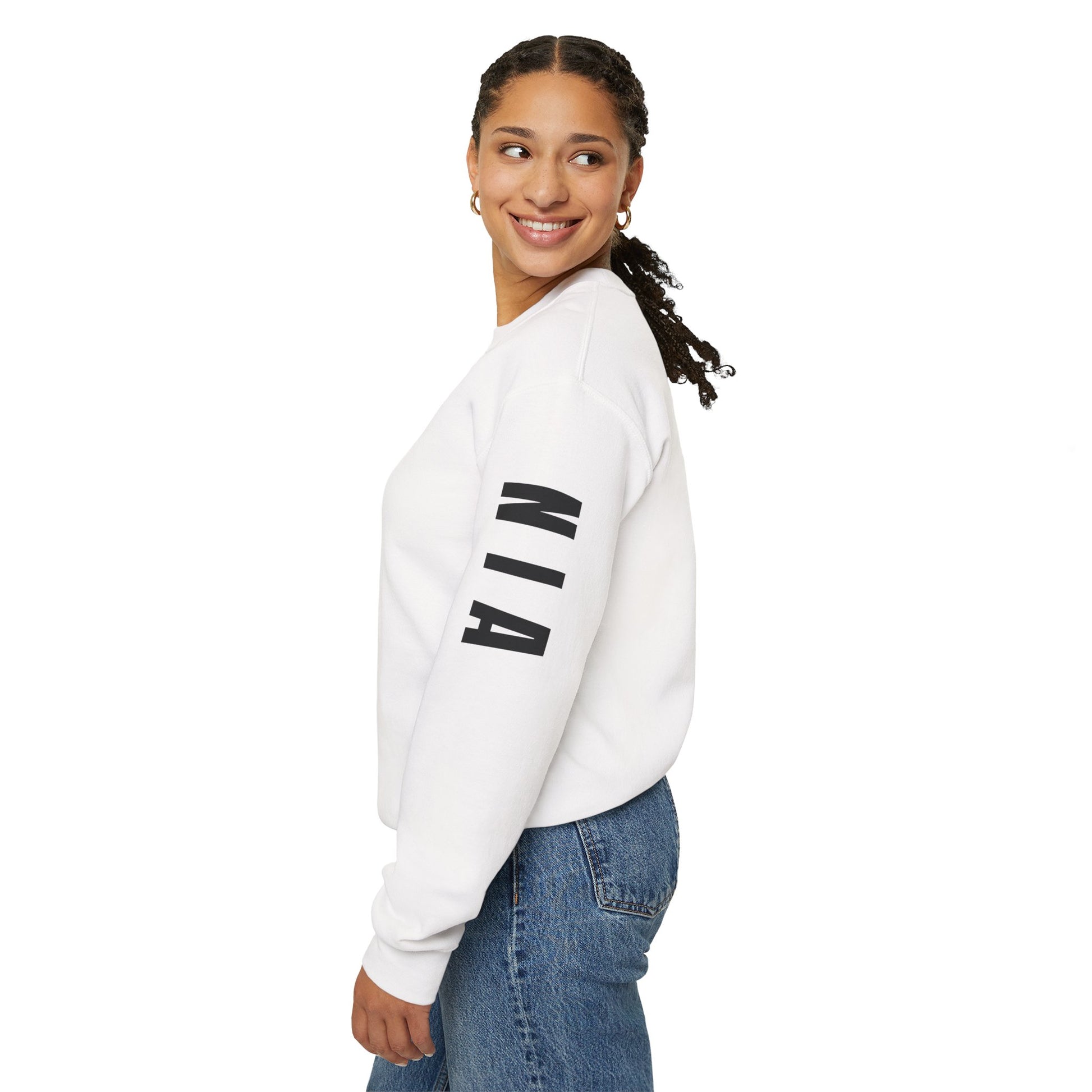 Woman wearing a white sweatshirt with 'NIA' on the sleeve against a white background