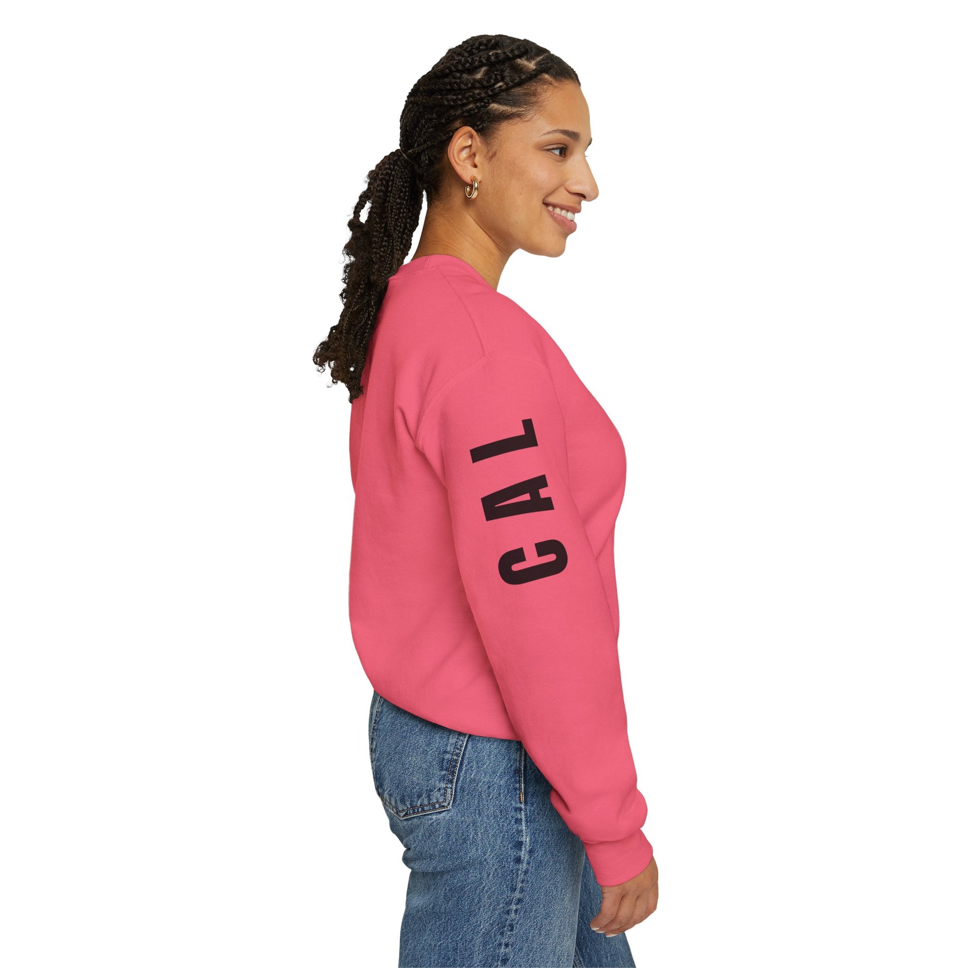 Woman wearing a pink sweatshirt with 'CAL' printed on it, standing against a white background